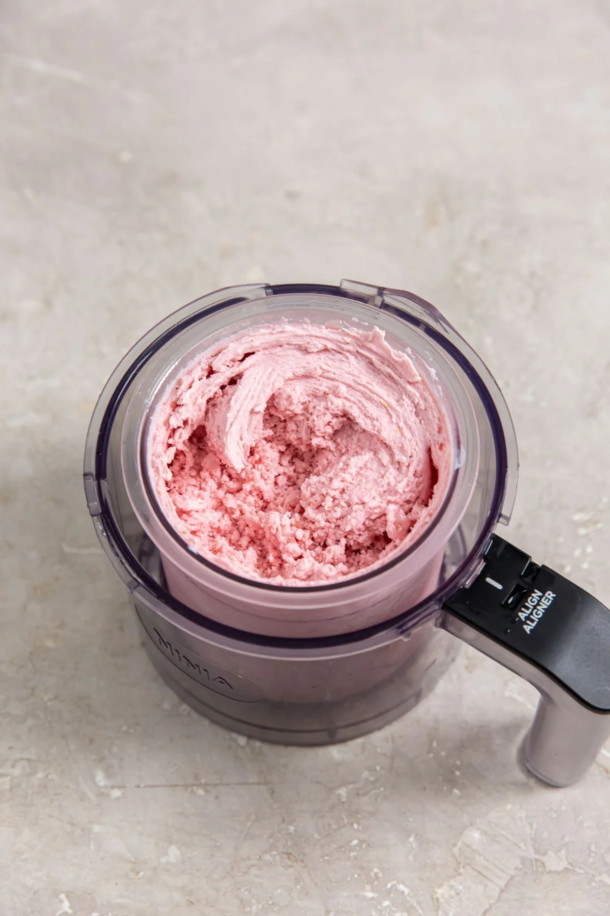 Vaso de Ninja Creami con helado proteico de fresa recién procesado